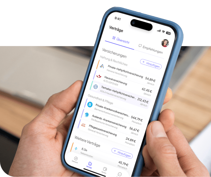 Eine Person hält ein Smartphone in der Hand. Auf dem Display ist eine App geöffnet, die eine Übersicht über verschiedene Versicherungsverträge zeigt. Es sind mehrere Versicherungen aufgelistet, darunter private Haftpflicht-, Hausrat-, Tierhalterhaftpflicht-, Kranken- und Pflegeversicherungen. Zu jeder Versicherung werden Name, Anbieter und monatlicher Beitrag angezeigt. Im Hintergrund liegen ein Notizbuch und ein Stift auf einem Tisch.
